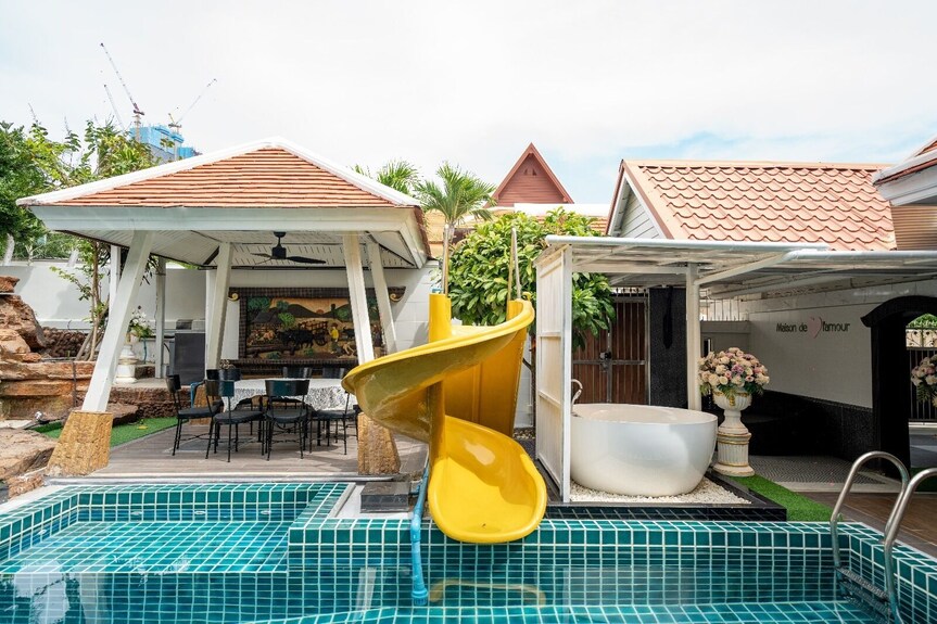 Covered poolside pavilion and yellow waterslide
